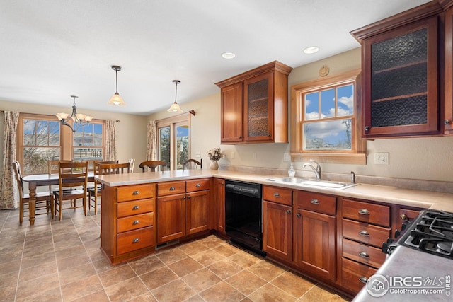 kitchen featuring light countertops, dishwasher, a peninsula, and a sink