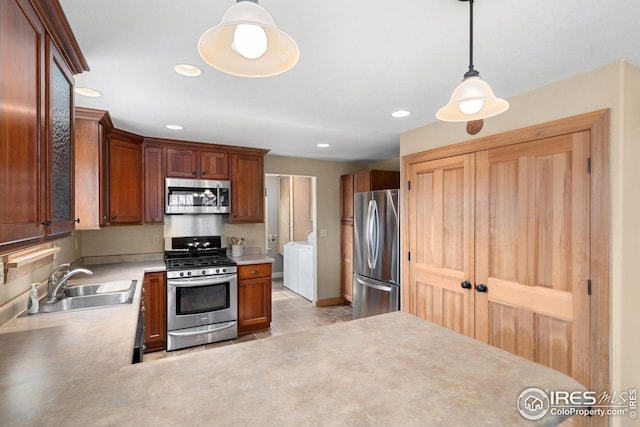 kitchen with decorative light fixtures, stainless steel appliances, recessed lighting, a sink, and separate washer and dryer