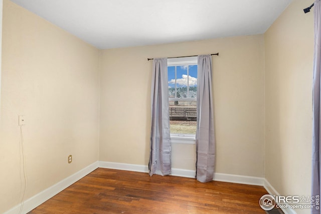 empty room featuring baseboards and wood finished floors