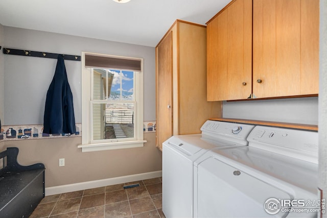 washroom featuring dark tile patterned flooring, independent washer and dryer, cabinet space, and baseboards