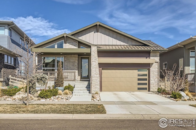 5626 Four Leaf Dr, Longmont, CO 80503 - view of front of home featuring driveway, stone siding, a standing seam roof, a porch, and board and batten siding
