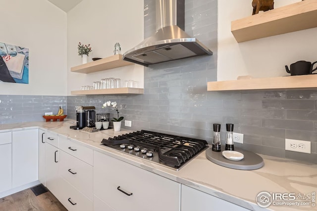 5626 Four Leaf Dr, Longmont, CO 80503 - kitchen with stainless steel gas cooktop, open shelves, backsplash, white cabinets, and wall chimney range hood