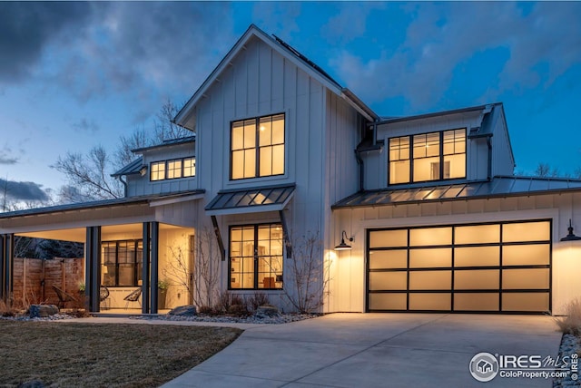 modern inspired farmhouse with board and batten siding, a standing seam roof, driveway, and metal roof