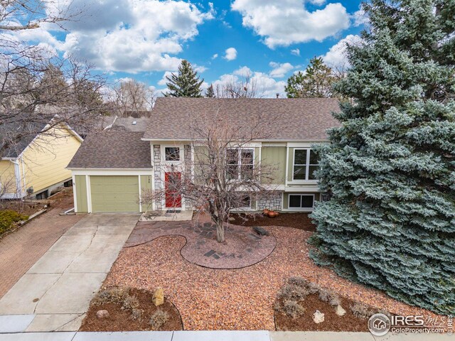 view of front of house with a garage, driveway, and a shingled roof