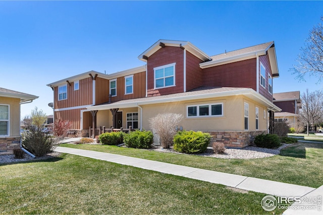 5850 Dripping Rock Ln, Fort Collins, CO 80528 - view of front of home with stone siding, a front yard, and stucco siding