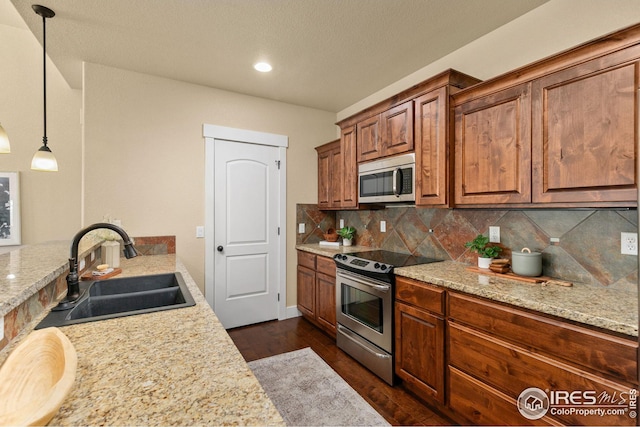 5850 Dripping Rock Ln, Fort Collins, CO 80528 - kitchen with appliances with stainless steel finishes, brown cabinets, dark wood-type flooring, a sink, and backsplash