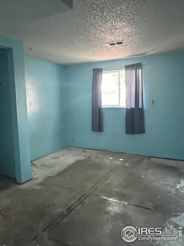 empty room with visible vents and a textured ceiling