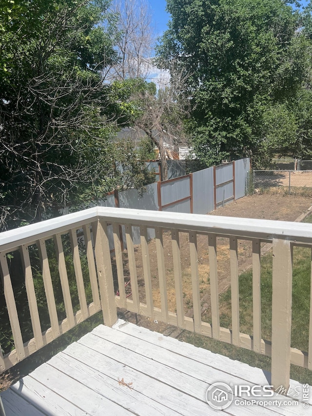 wooden deck with a fenced backyard