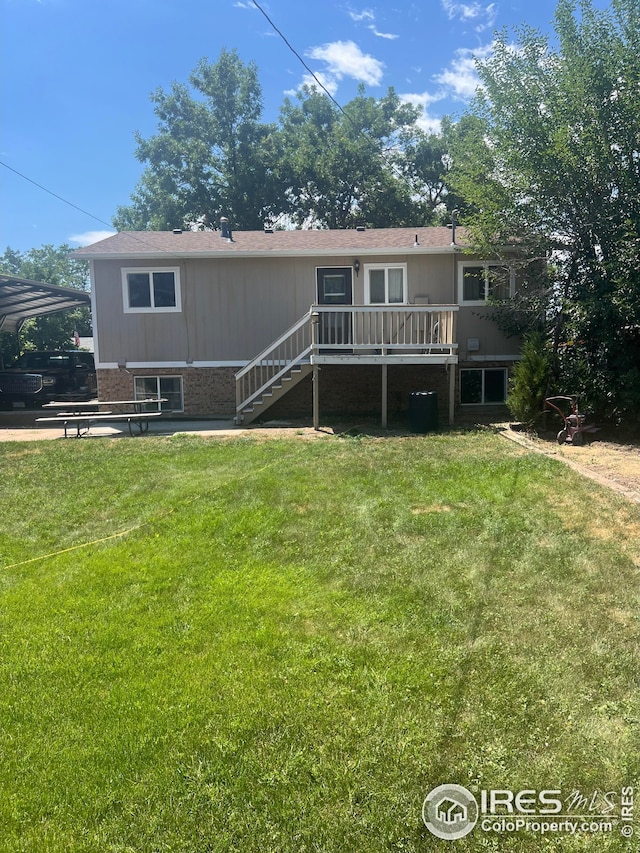 view of front of house with a deck, brick siding, a front yard, and stairs