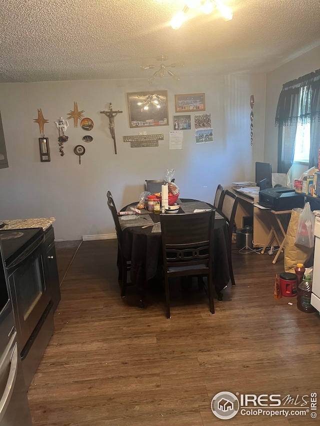 dining space with a textured ceiling and wood finished floors