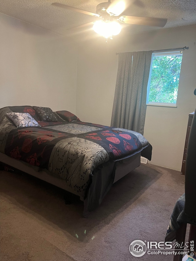 bedroom with a textured ceiling, ceiling fan, and carpet flooring