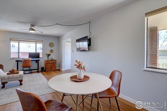1105 Bacchus Dr Unit 8, Lafayette, CO 80026 - dining area featuring a textured ceiling, ceiling fan, light wood finished floors, and baseboards