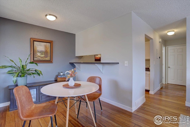 1105 Bacchus Dr Unit 8, Lafayette, CO 80026 - dining space with baseboards, a textured ceiling, and light wood-style floors
