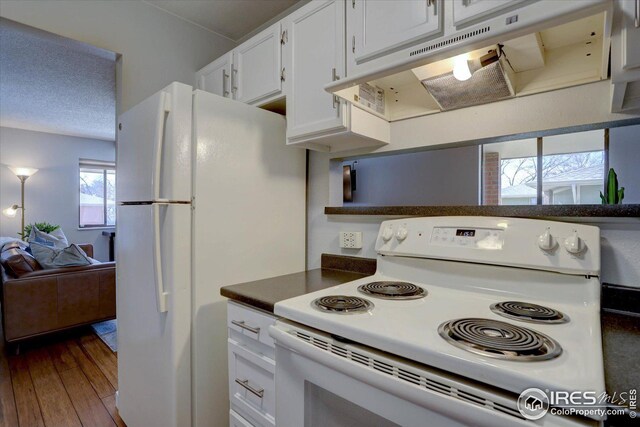 1105 Bacchus Dr Unit 8, Lafayette, CO 80026 - kitchen featuring dark countertops, dark wood-type flooring, white cabinetry, white appliances, and under cabinet range hood
