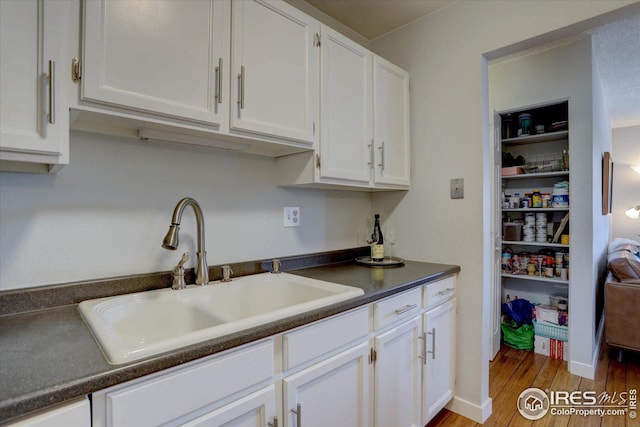1105 Bacchus Dr Unit 8, Lafayette, CO 80026 - kitchen featuring dark countertops, white cabinetry, and a sink