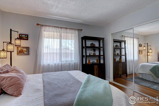 1105 Bacchus Dr Unit 8, Lafayette, CO 80026 - bedroom featuring a closet, a textured ceiling, and wood finished floors
