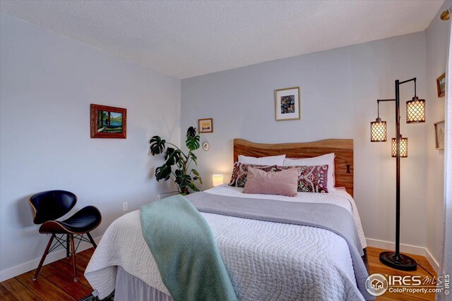 1105 Bacchus Dr Unit 8, Lafayette, CO 80026 - bedroom featuring a textured ceiling, baseboards, and wood finished floors