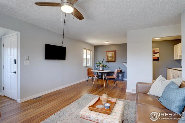 1105 Bacchus Dr Unit 8, Lafayette, CO 80026 - living area featuring baseboards, a textured ceiling, visible vents, and light wood-style floors