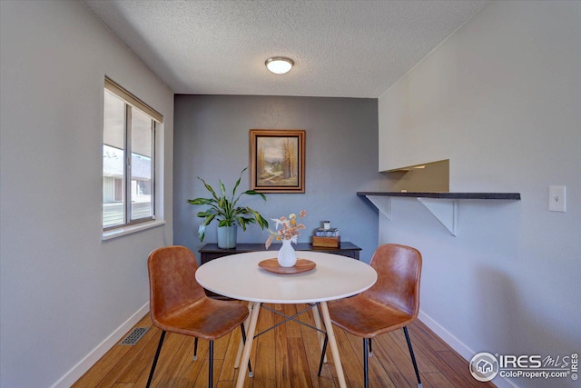 1105 Bacchus Dr Unit 8, Lafayette, CO 80026 - dining area with baseboards, a textured ceiling, visible vents, and hardwood / wood-style floors