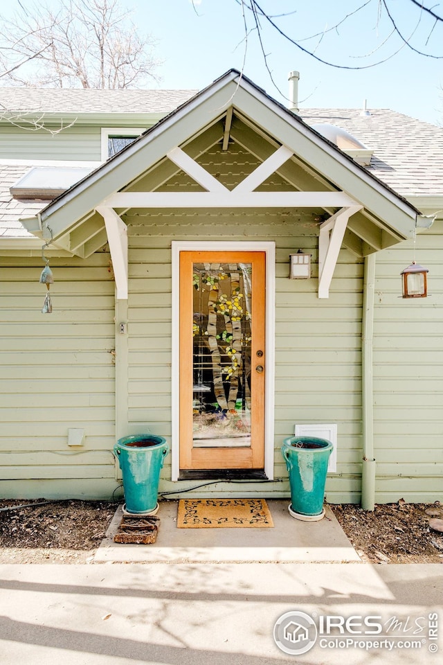 property entrance with roof with shingles