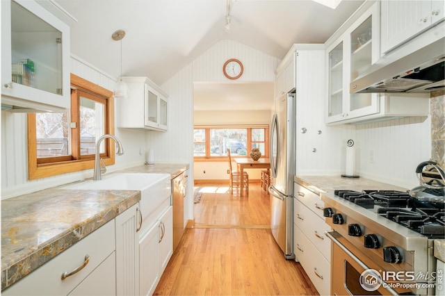 kitchen featuring light wood-style flooring, under cabinet range hood, white cabinetry, vaulted ceiling, and appliances with stainless steel finishes