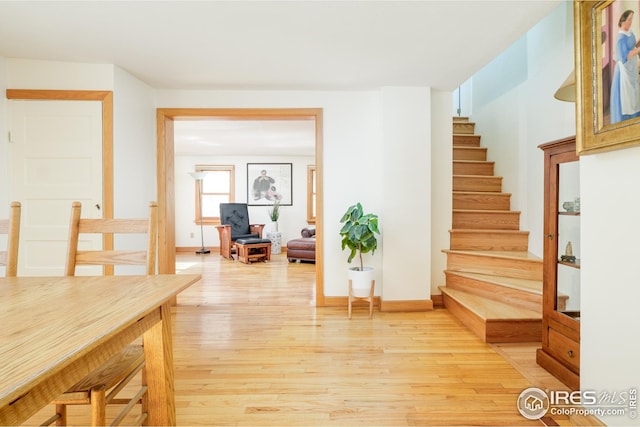 interior space with light wood finished floors, stairs, and baseboards