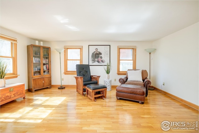 living area featuring light wood-type flooring and baseboards