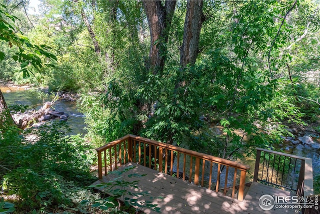 wooden terrace featuring a wooded view