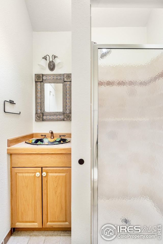 bathroom with a shower stall and vanity