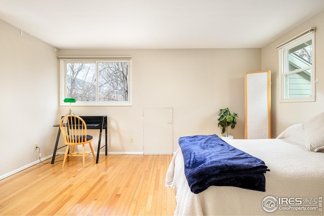 bedroom with wood-type flooring and baseboards