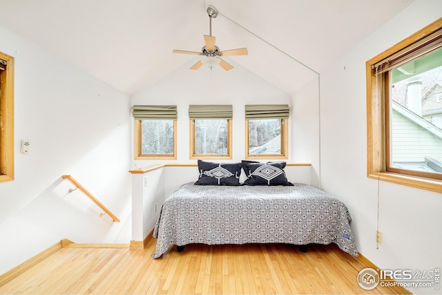 bedroom featuring lofted ceiling, ceiling fan, hardwood / wood-style floors, and multiple windows