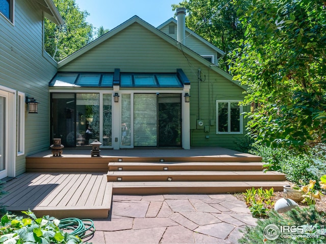 rear view of property featuring a deck