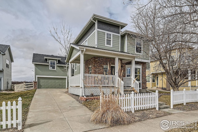 view of front of home with covered porch, brick siding, a fenced front yard, and a garage