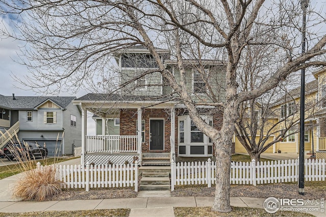 view of front of home featuring a porch, a fenced front yard, and brick siding