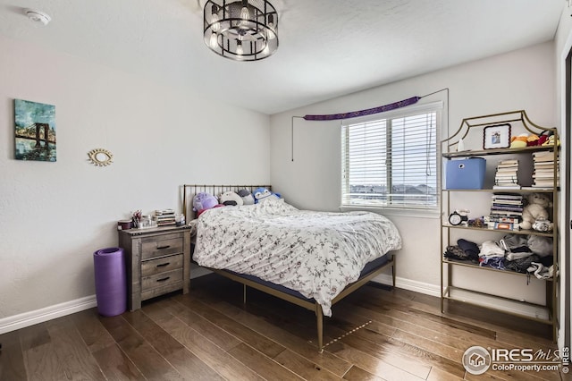 5541 Tullamore Ct, Timnath, CO 80547 - bedroom featuring baseboards, wood finished floors, and a chandelier
