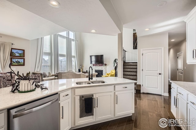 5541 Tullamore Ct, Timnath, CO 80547 - kitchen featuring stainless steel dishwasher, a sink, dark wood-style floors, open floor plan, and white cabinets
