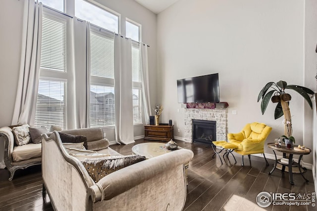5541 Tullamore Ct, Timnath, CO 80547 - living area featuring dark wood-style floors, a high ceiling, a fireplace, and baseboards