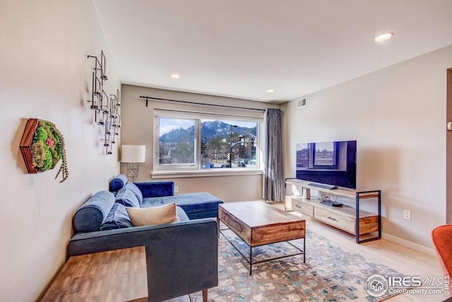 living room with recessed lighting, wood finished floors, visible vents, and baseboards