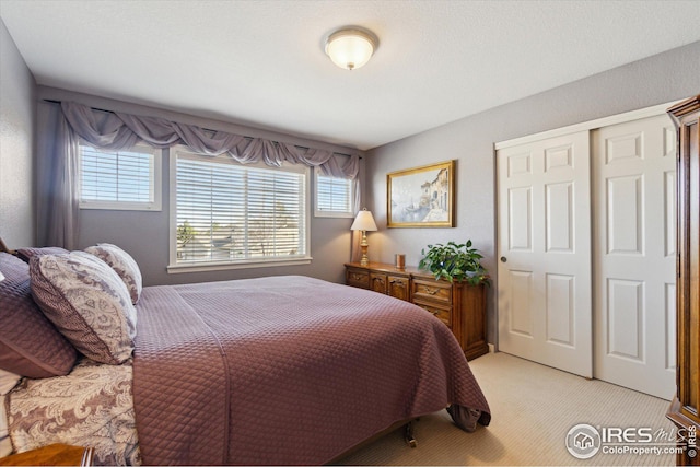 bedroom with light colored carpet and a closet