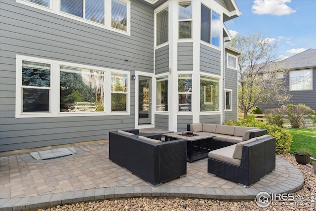 view of patio with an outdoor living space with a fire pit