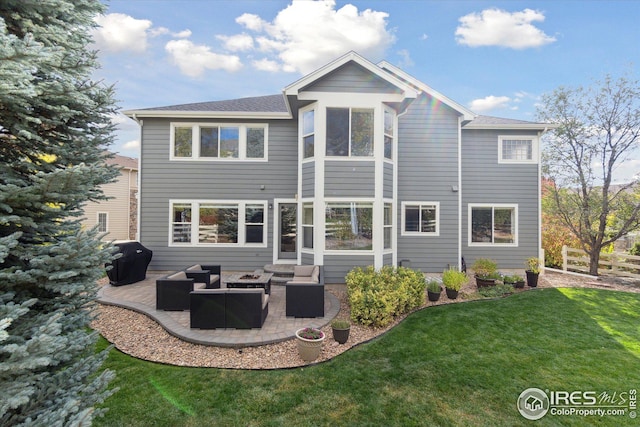 back of house featuring fence, a patio area, a lawn, and a fire pit