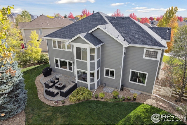 rear view of house with a lawn, a fire pit, fence, and a shingled roof