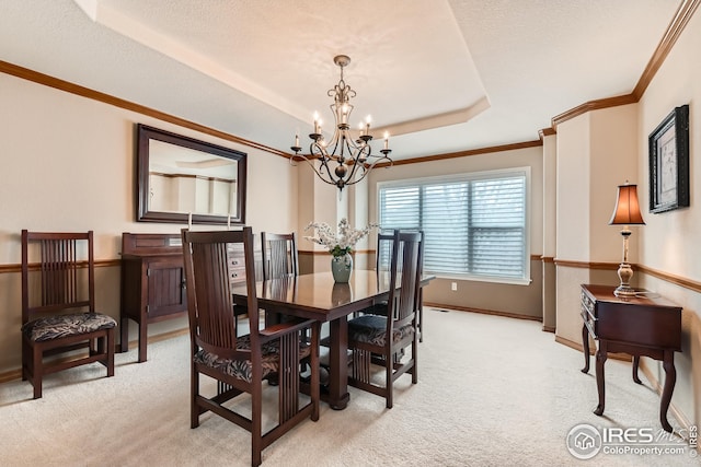 dining area with ornamental molding, baseboards, light carpet, and an inviting chandelier