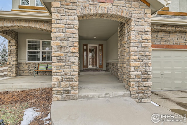 entrance to property featuring stone siding and stucco siding