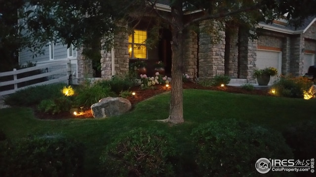 view of yard featuring fence and a garage