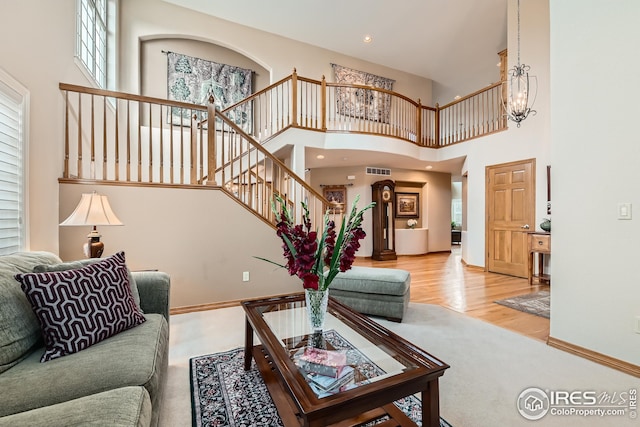 living room with a chandelier, a healthy amount of sunlight, stairs, and visible vents
