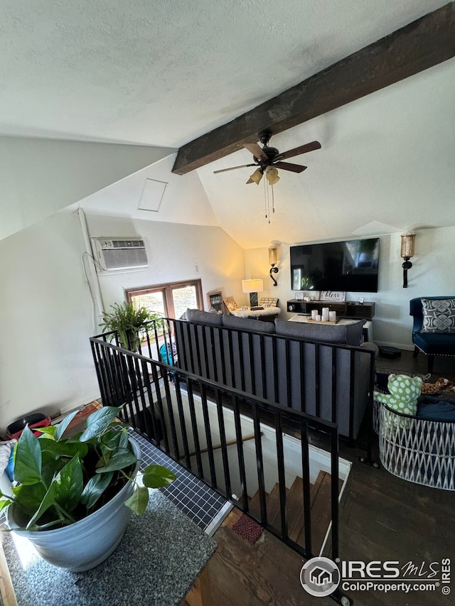 interior space with lofted ceiling with beams, a textured ceiling, and wood finished floors