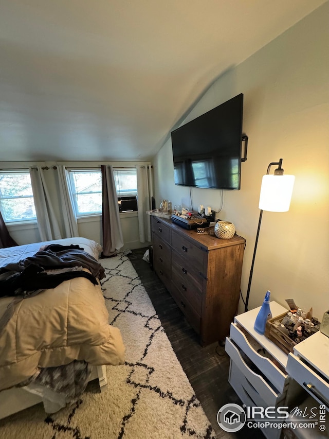 bedroom with lofted ceiling and dark wood-style flooring