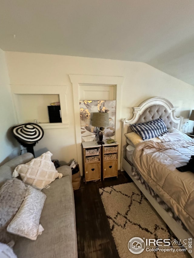 bedroom with dark wood-style flooring and vaulted ceiling