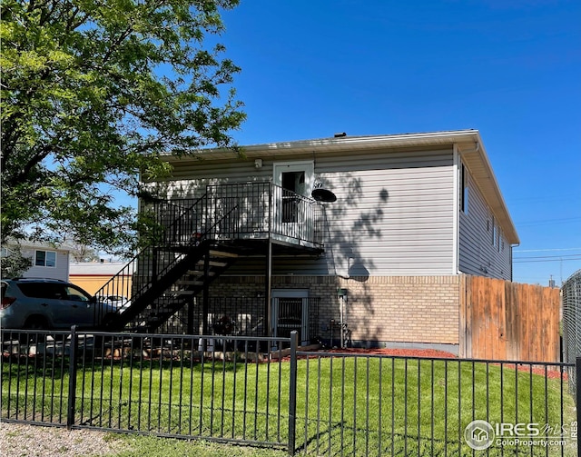 view of front of property with stairs, brick siding, a front yard, and fence